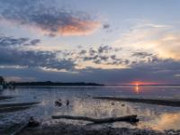Sonnenaufgang beim Harrasser Moosgraben mit leuchtender Wolke über Insel Herrenchiemsee